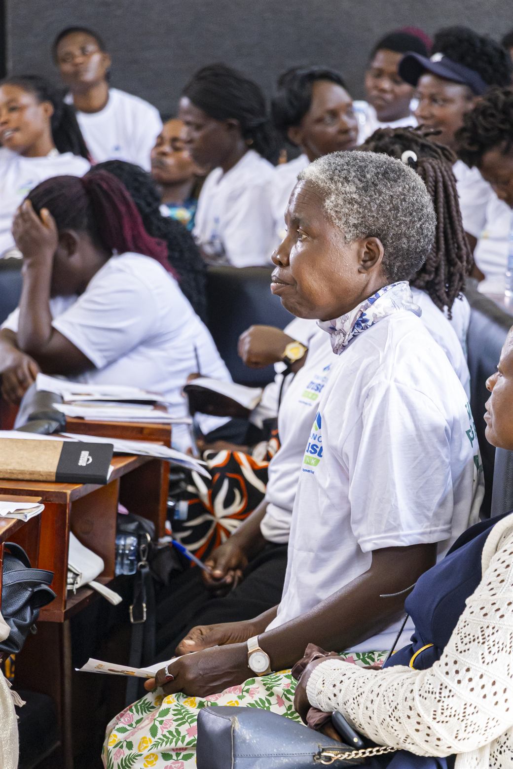 Documentary still of a woman entrepreneur studying financial planning materials during a district TEP workshop.